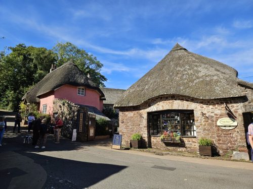 אנגליה הכפרית טיול ברחוב כפרי ב-Cockington Village ליד Torquay, דרום Devon – בתי אבן וגגות קש מסורתיים